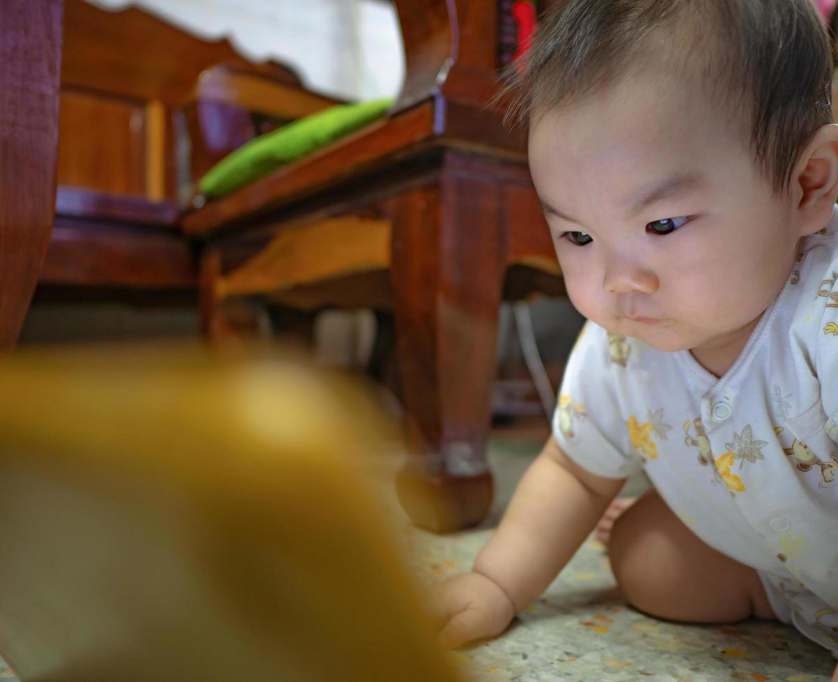 cutie asiático varón bebé muy serio y mira la tableta foto