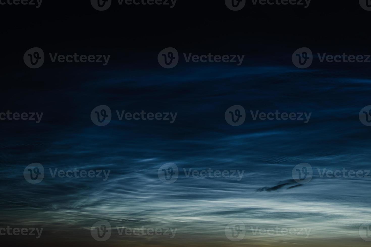 Noctilucent mesospheric clouds in night sky. Rare atmospheric phenomenon over city. photo
