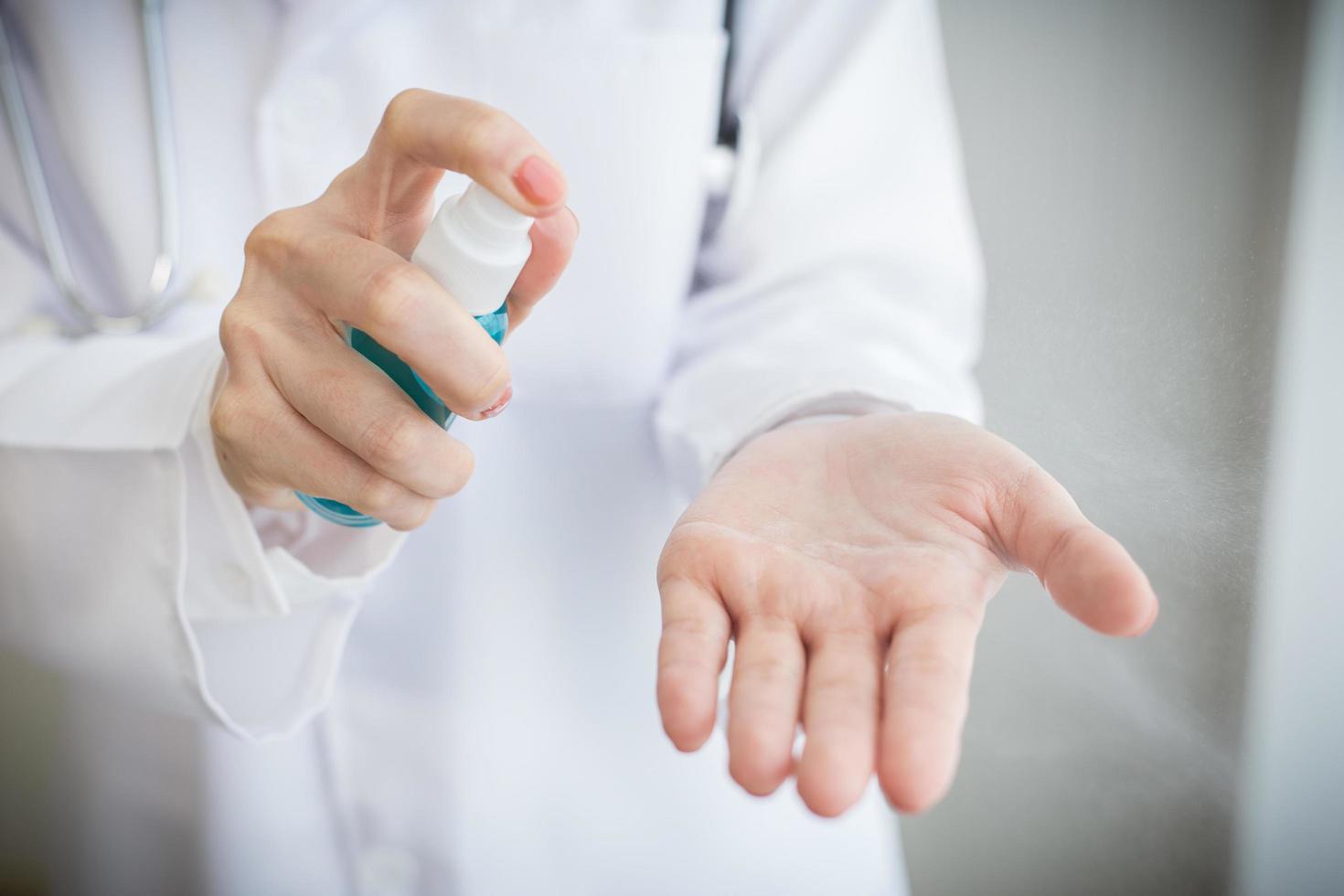 Cleaning hands with sanitizer alcohol spray. photo