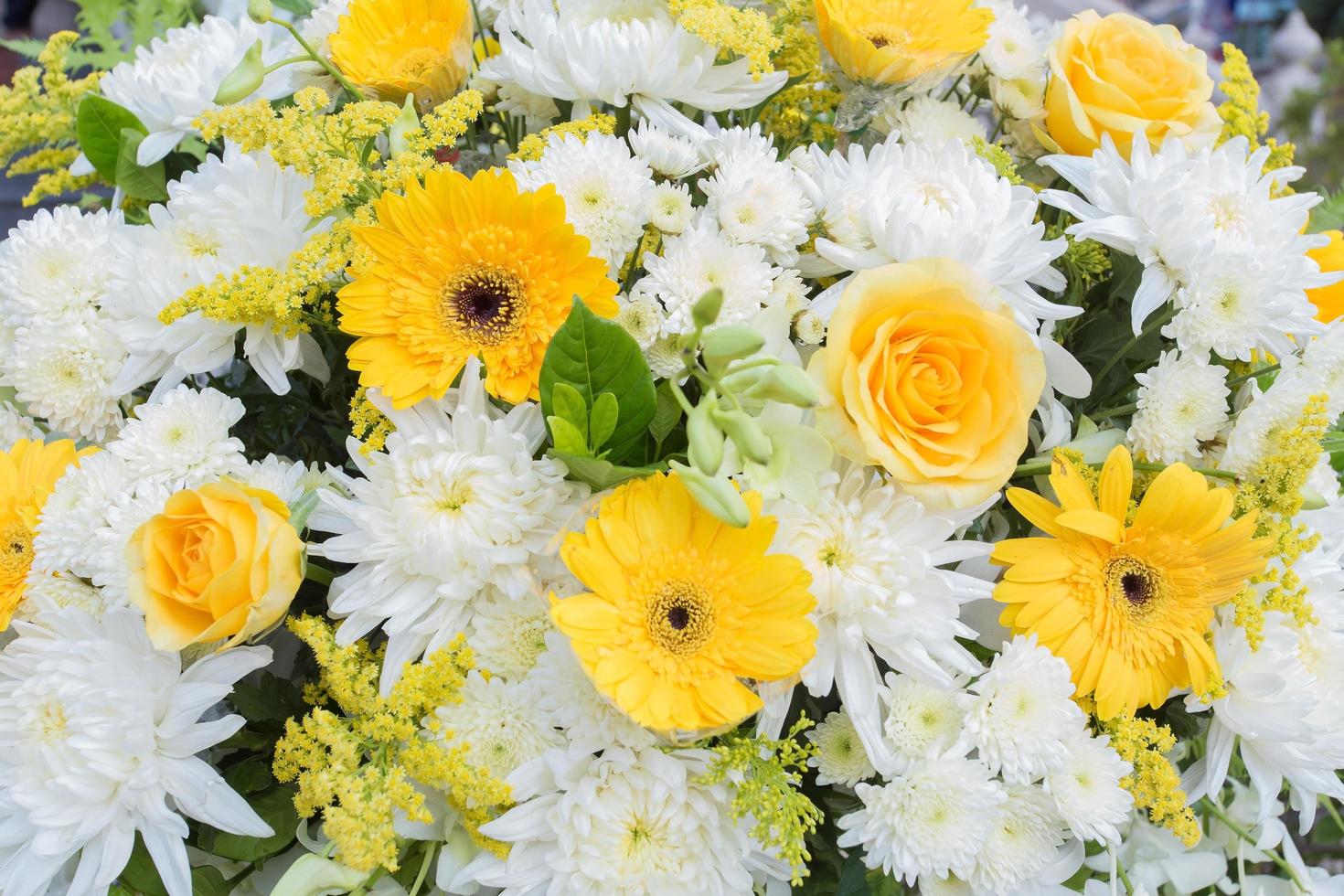 Yellow and white Chrysanthemum flowers, rose was decorated with green leaves as wreath to use in funeral. photo