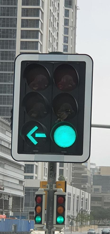 Green traffic light with green arrow light up in city while sunset allows car to turn right photo