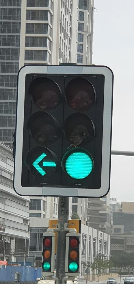 semáforo verde con flecha verde iluminada en la ciudad mientras la puesta de sol permite que el camión gire a la derecha foto