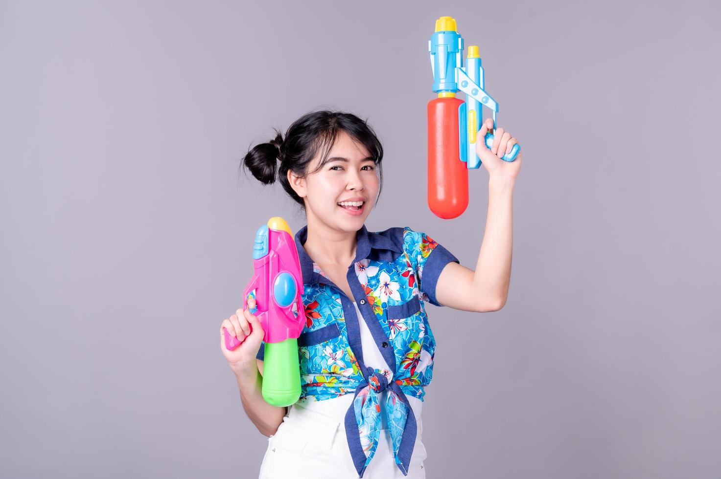 Beautiful Asian women hold plastic water guns at an ancient temple during Songkran, the most beautiful and fun water festival in Thailand photo