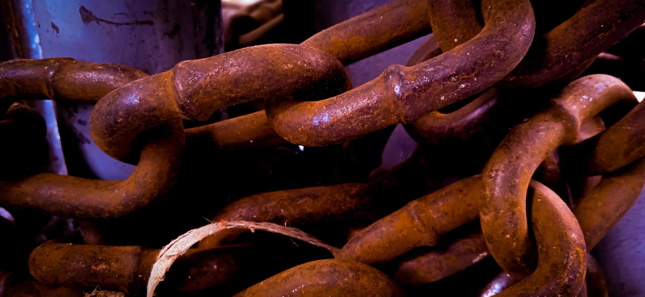 Yellow corroded iron chain wrapped around on the iron pole. photo