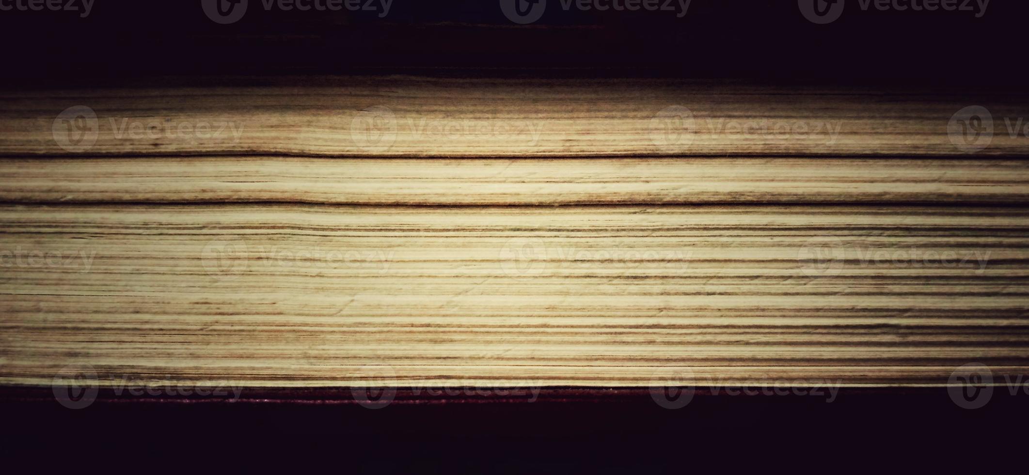 Paper layers in the old book with a dim or dark background. Suitable for private and commercial advertising of library, office, campus, and school informations. photo