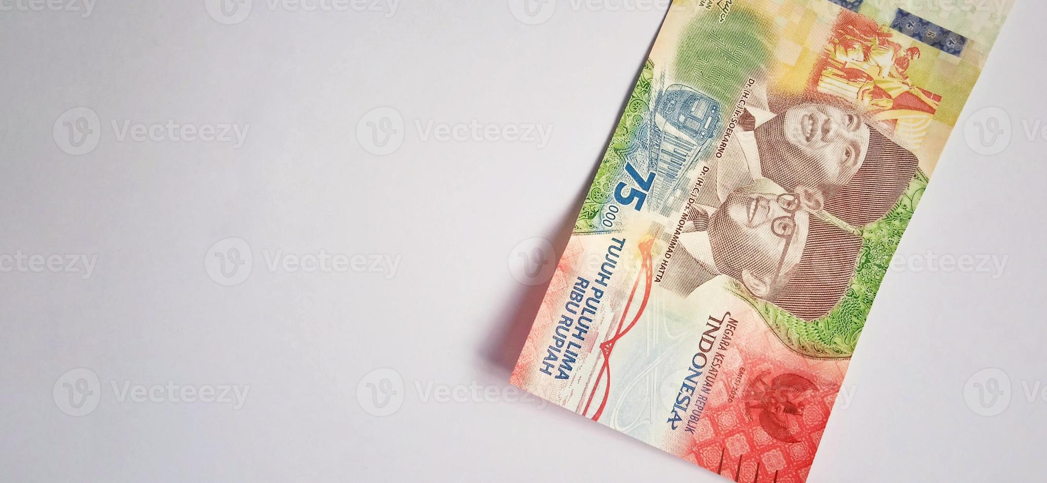 un nuevo billete de 75.000 rupias del banco indonesia con fondo gris. emitido durante la 75ª independencia nacional de indonesia el 17 de agosto de 2020, período de 1945-2020. moneda indonesia. foto