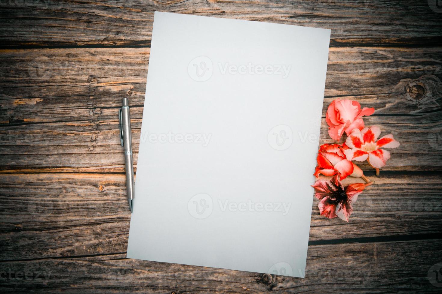 Pink azalea flowers with silver color pencil and blank paper sheet on a wooden background, top view, Blank template for your text. flat lay. photo