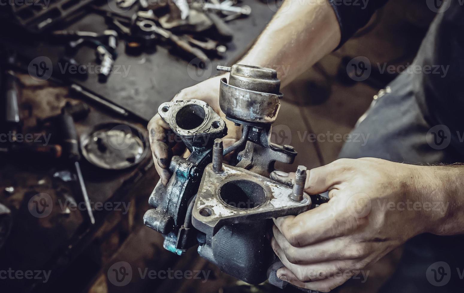 the hands of mechanics hold the turbine of a car motor photo