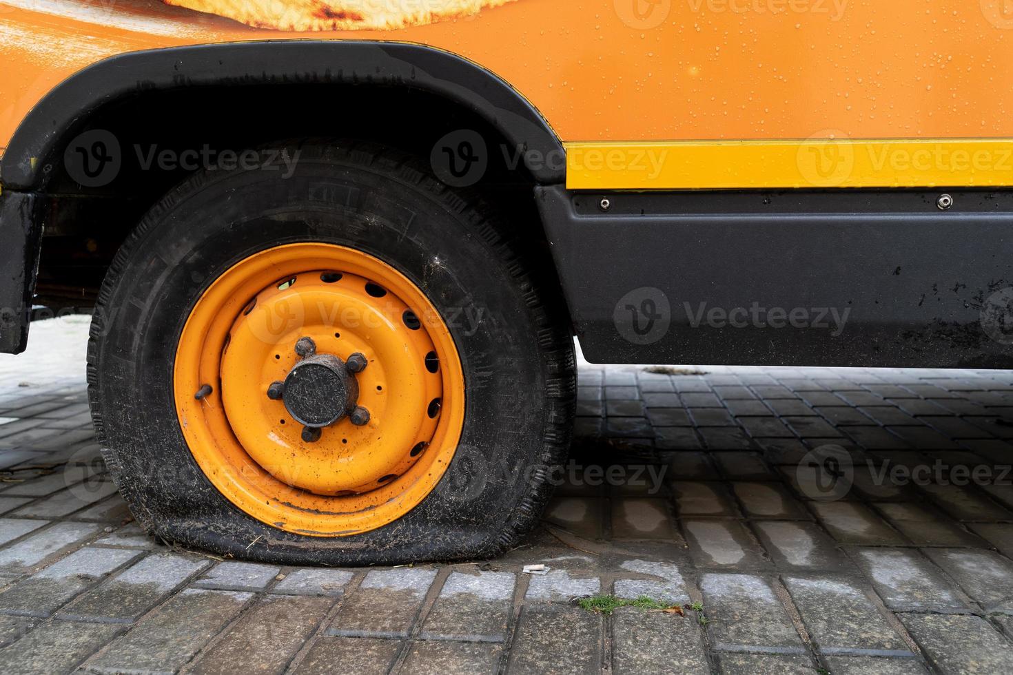 vintage orange minibus with a flat wheel photo