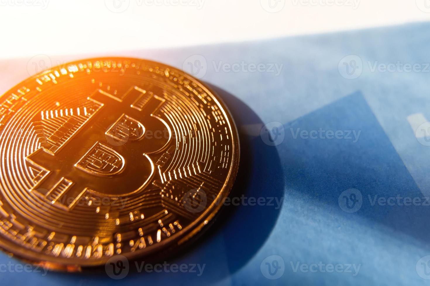 moneda bitcoin sobre un fondo azul con un resplandor del sol. foto