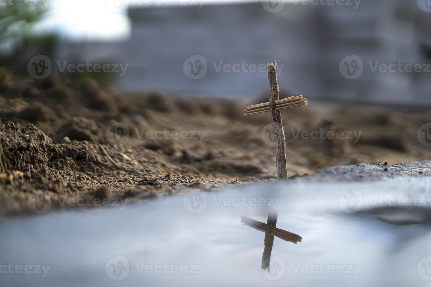 Christian cross made of wood on a background of sand photo