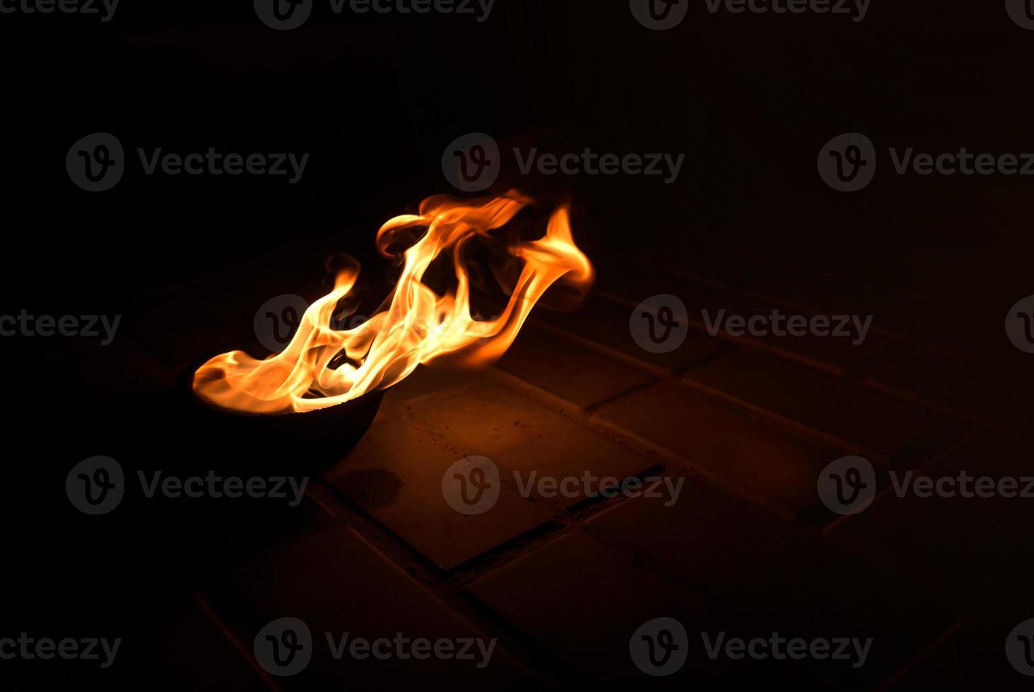 fire burns in a bowl on the ground photo