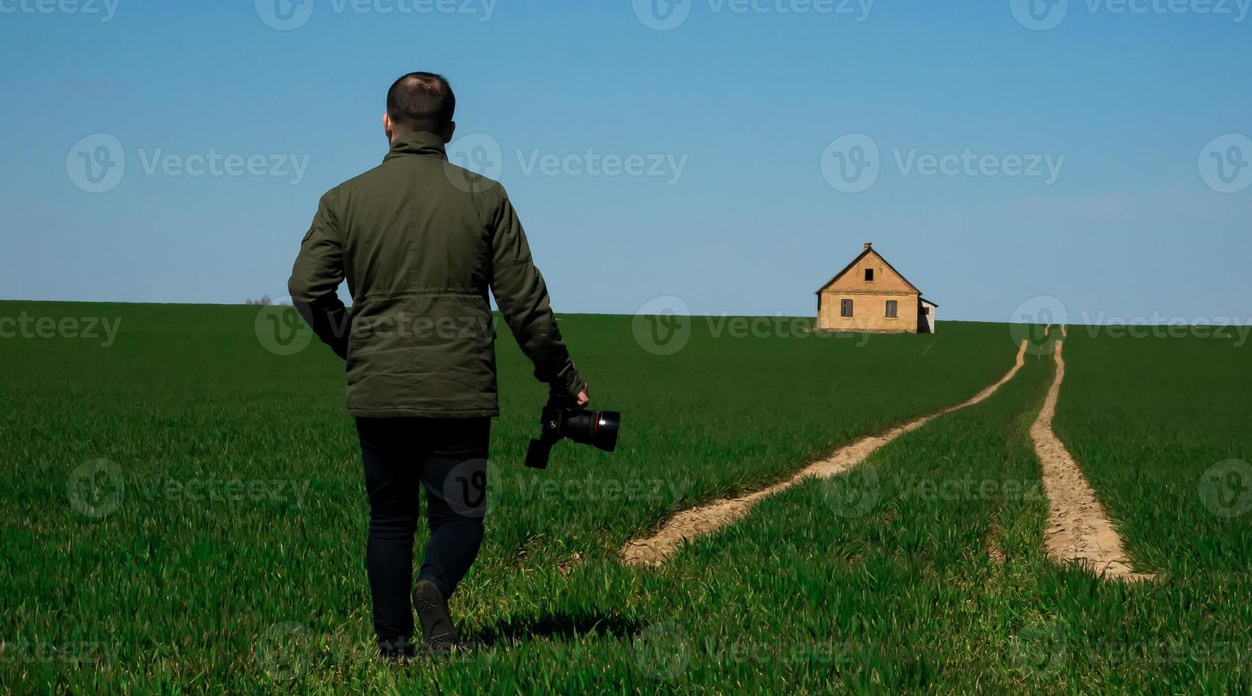 Photograph with a camera in hand walking down the road photo