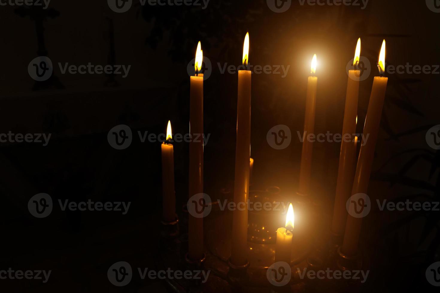 Burning candles on a dark background in the temple photo