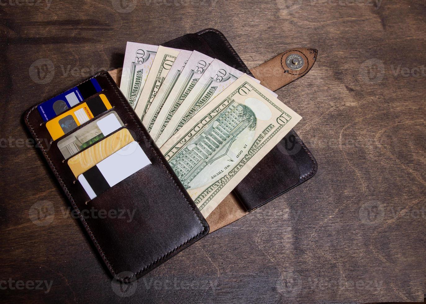 leather wallet with money and cards lying on the table photo