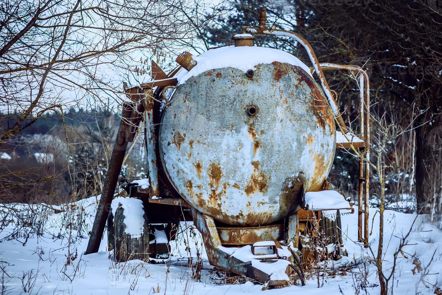 Rusty barrel in winter forest photo