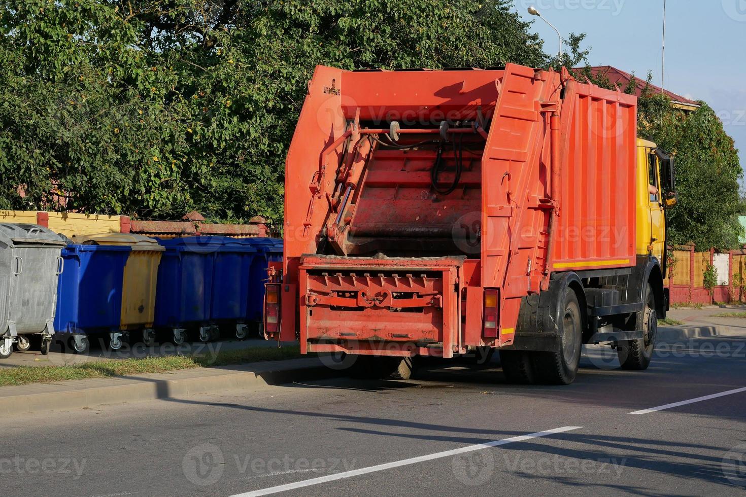 camión de basura cerca de contenedores de basura foto