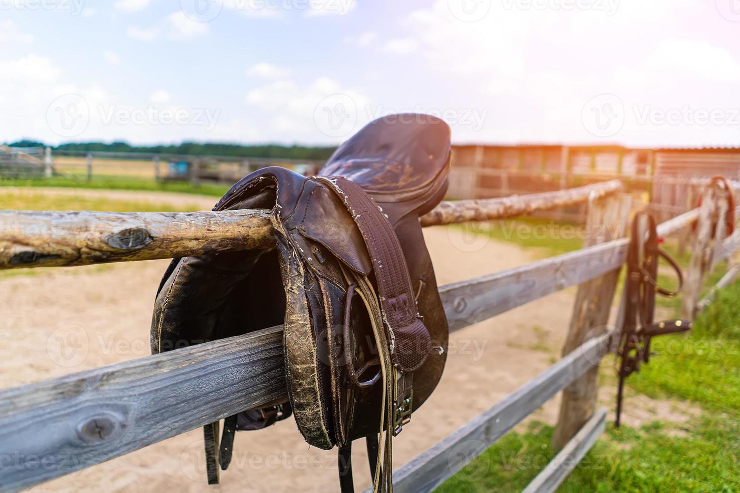 horse saddle hanging on a fence close-up photo