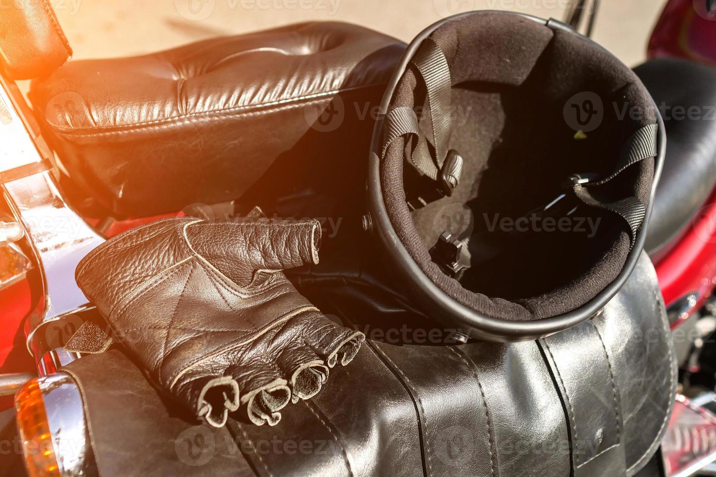 helmet and gloves are on the seat of the motorcycle photo