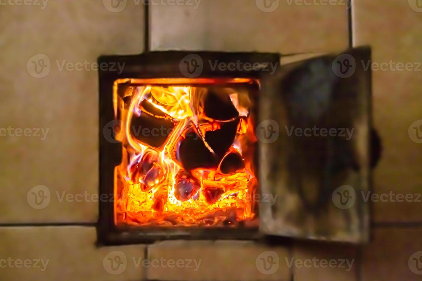 hermosa chimenea antigua con fuego de llama ligera para calentar la habitación del edificio foto