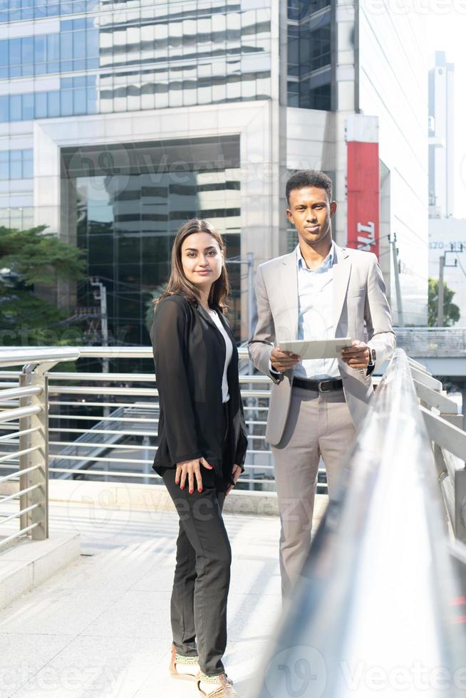 Business people meeting talking and sharing their ideas in city. Business team and teamwork concept. Business people standing outside in the city discussing about new project. photo