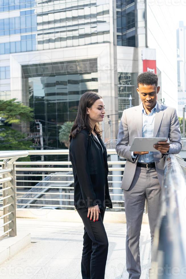Business people meeting talking and sharing their ideas in city. Business team and teamwork concept. Business people standing outside in the city discussing about new project. photo