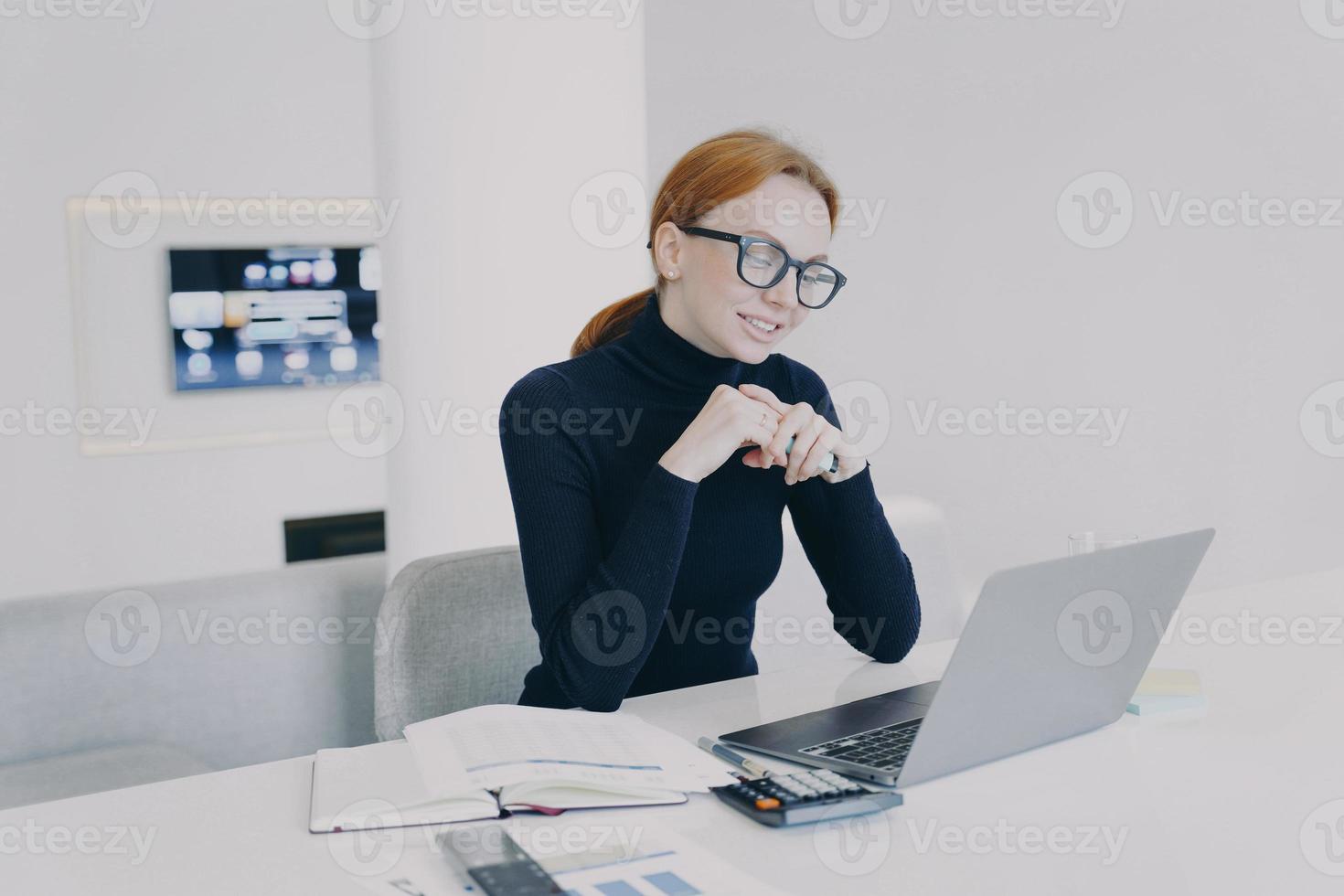 Businesswoman in glasses has online business video conference and smiling at camera. photo