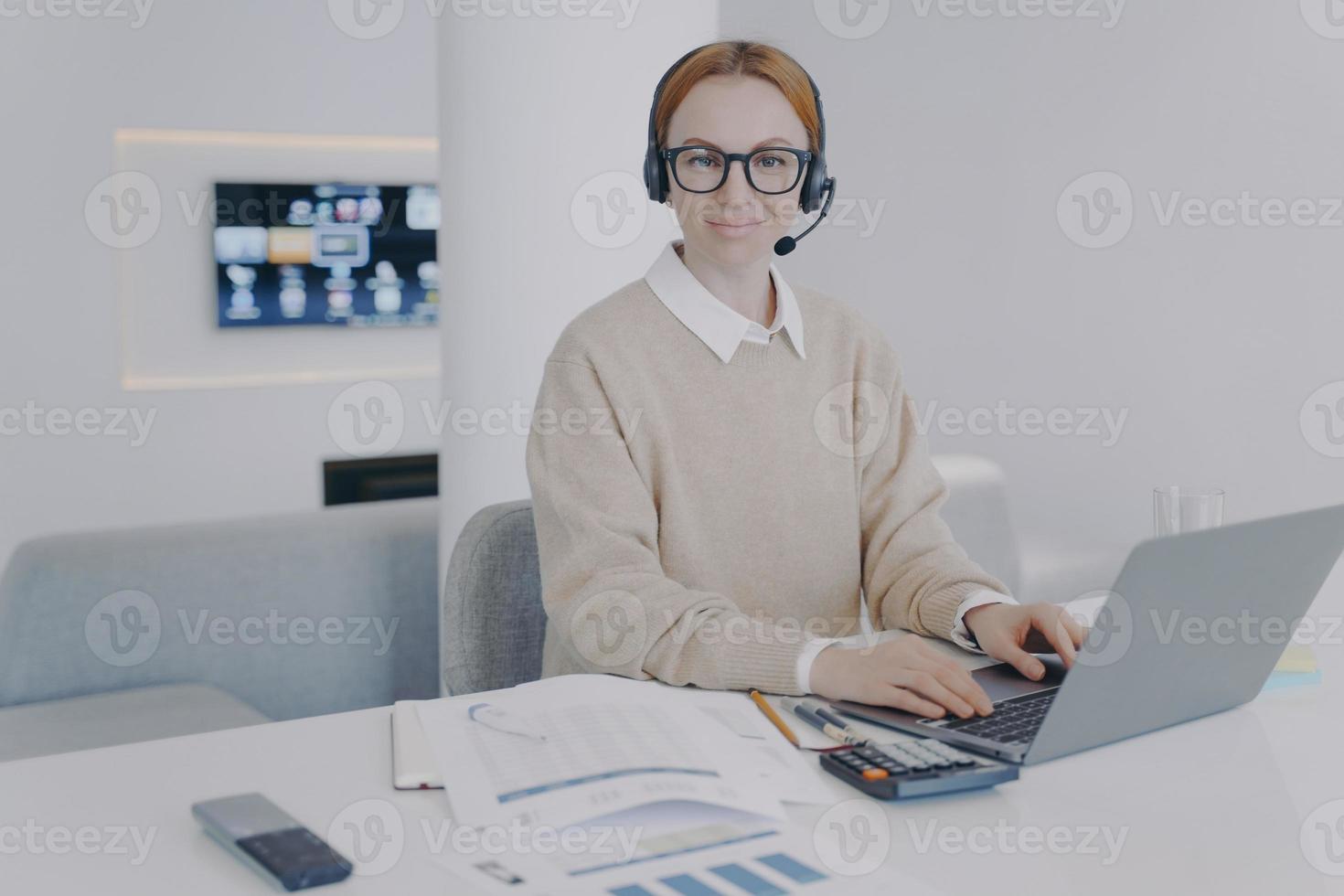 administrador del sistema en el lugar de trabajo. mujer joven en auriculares es consultora del centro de llamadas. foto