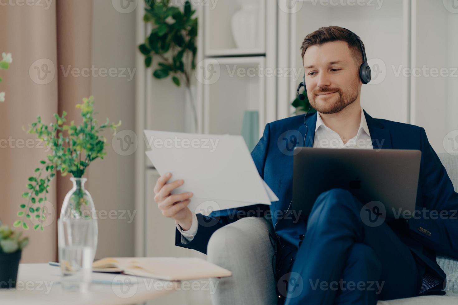 Young businessman with headset working at home remotely photo