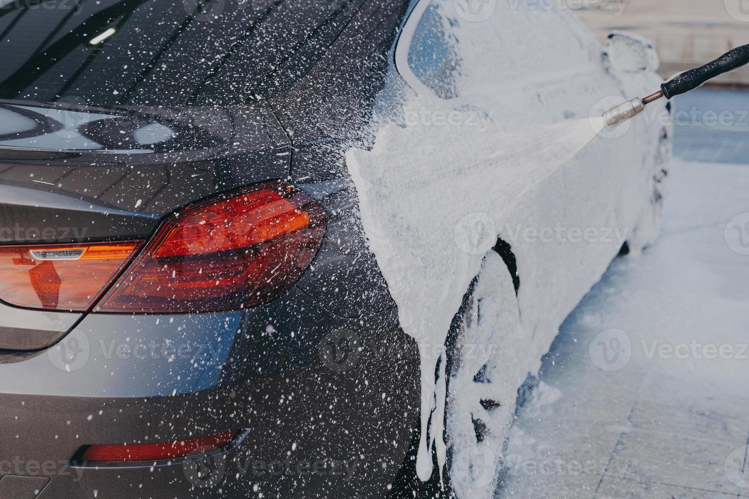 limpieza exterior del camión, aplicación de espuma de nieve en la superficie sucia del automóvil de la lavadora de alta presión foto