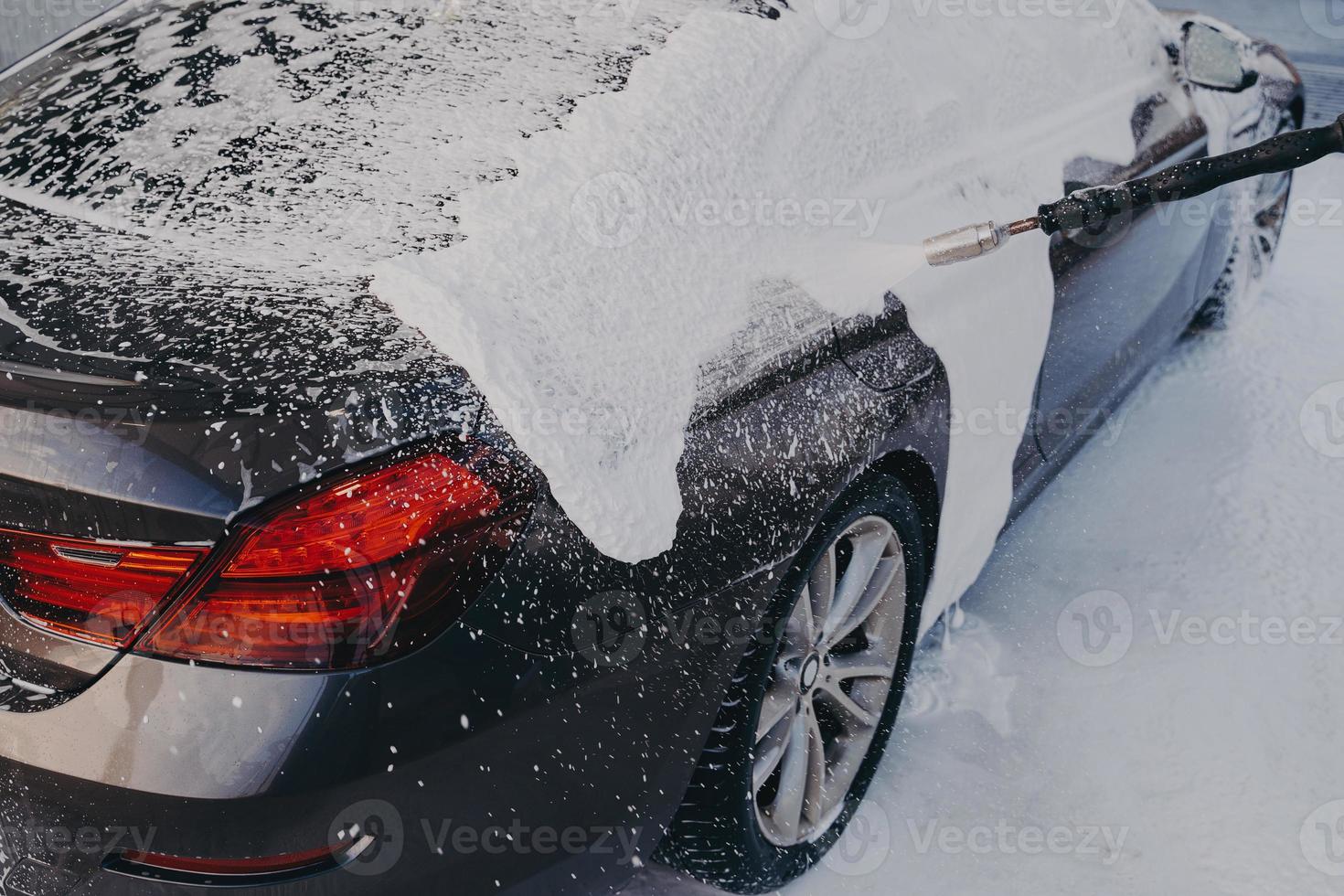 coche en espuma de jabón blanco durante la limpieza automática profesional al aire libre foto