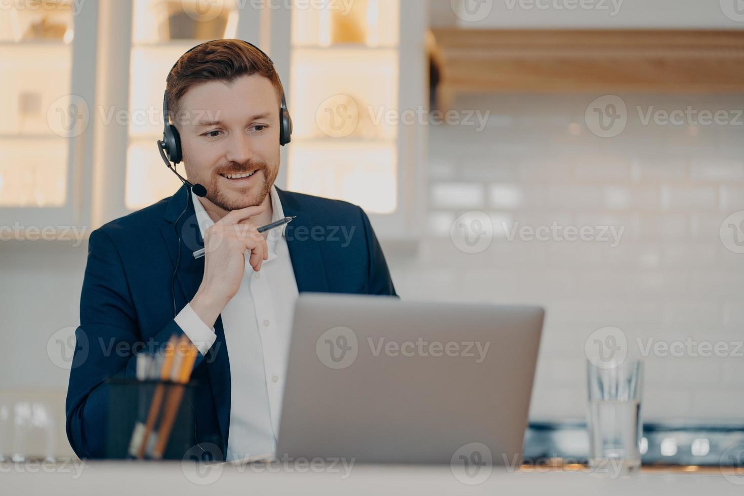 joven feliz discutiendo proyecto de trabajo en línea en casa foto