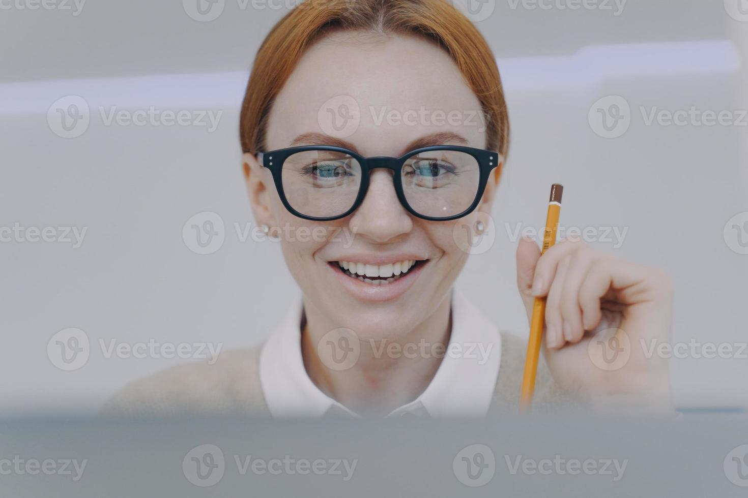 mujer joven estudiando con cámara. estudiante feliz sosteniendo un lápiz y tomando notas. la educación a distancia. foto