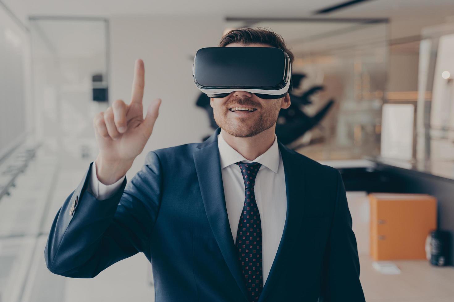 joven empresario exitoso en gafas vr tocando el aire con el dedo durante una reunión de negocios virtual foto