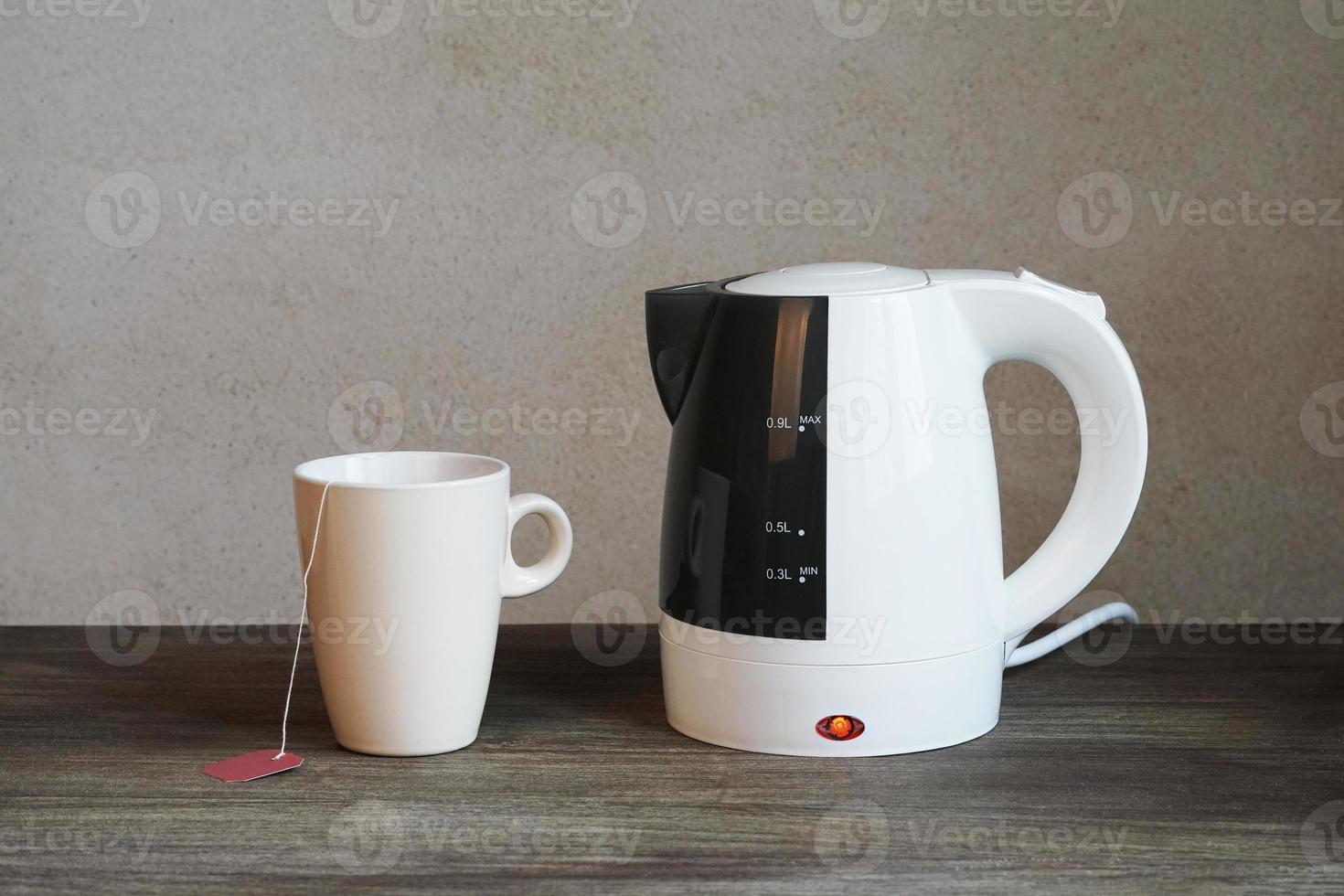 hervidor de agua eléctrico y taza de té foto