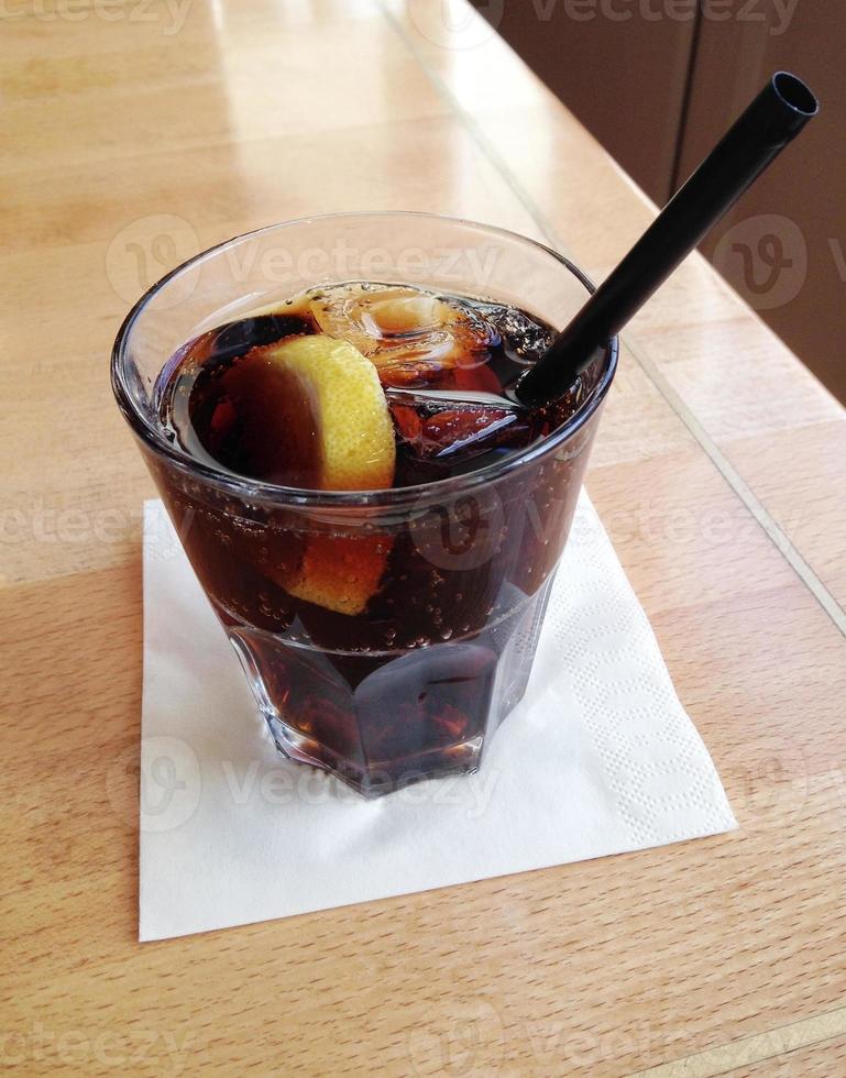 cola with lemon slice and ice cubes photo