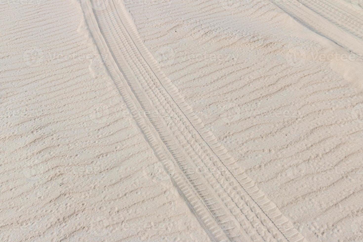 rastro de neumáticos en la arena de las dunas en la playa o el desierto. foto