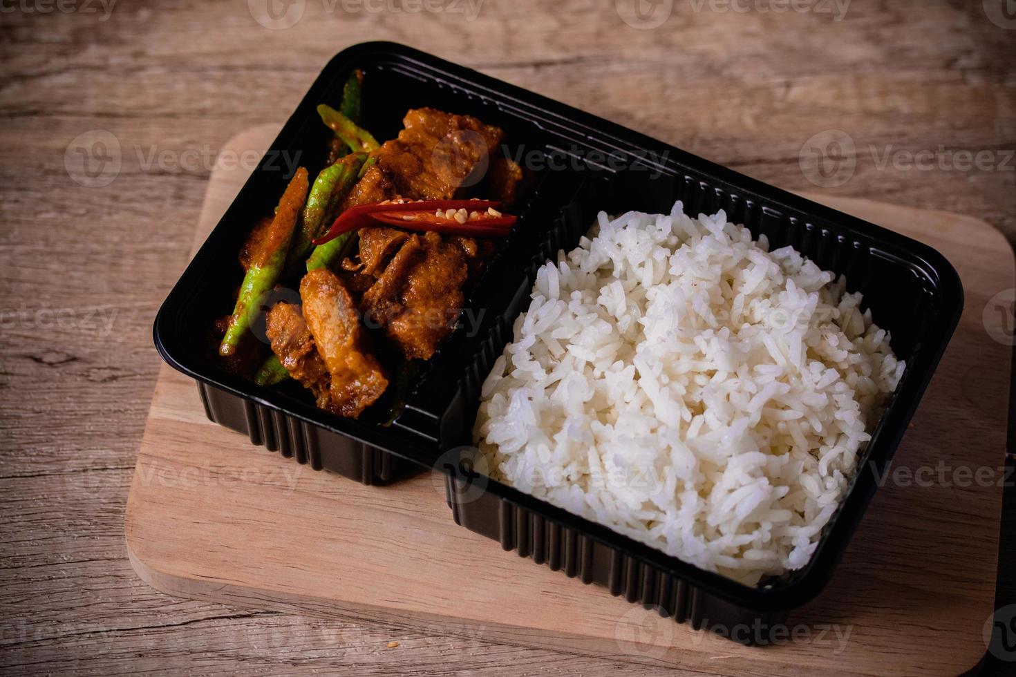 Stir-fried curry paste with crispy pork in a black box.Delivery Food Box photo