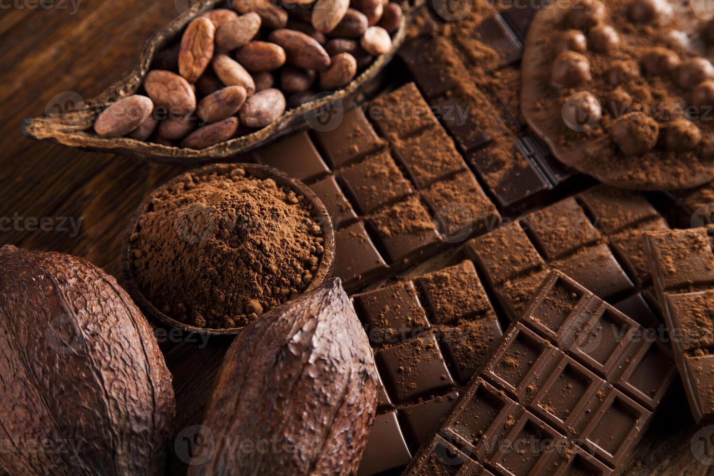 Dark homemade chocolate bars and cocoa pod on wooden photo