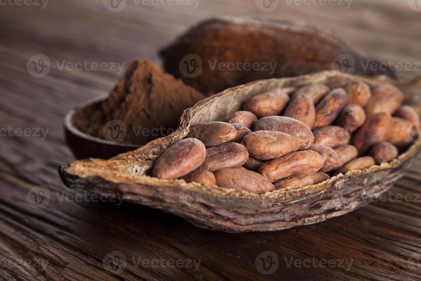 granos de cacao en la fruta seca de la vaina de cacao sobre fondo de madera foto