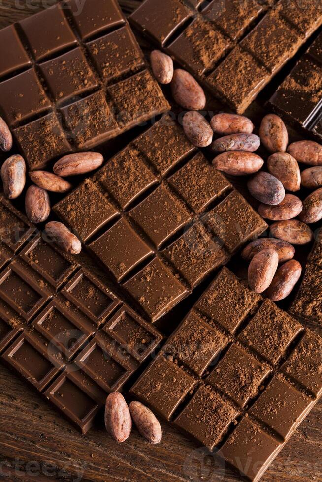 Dark homemade chocolate bars and cocoa pod on wooden photo