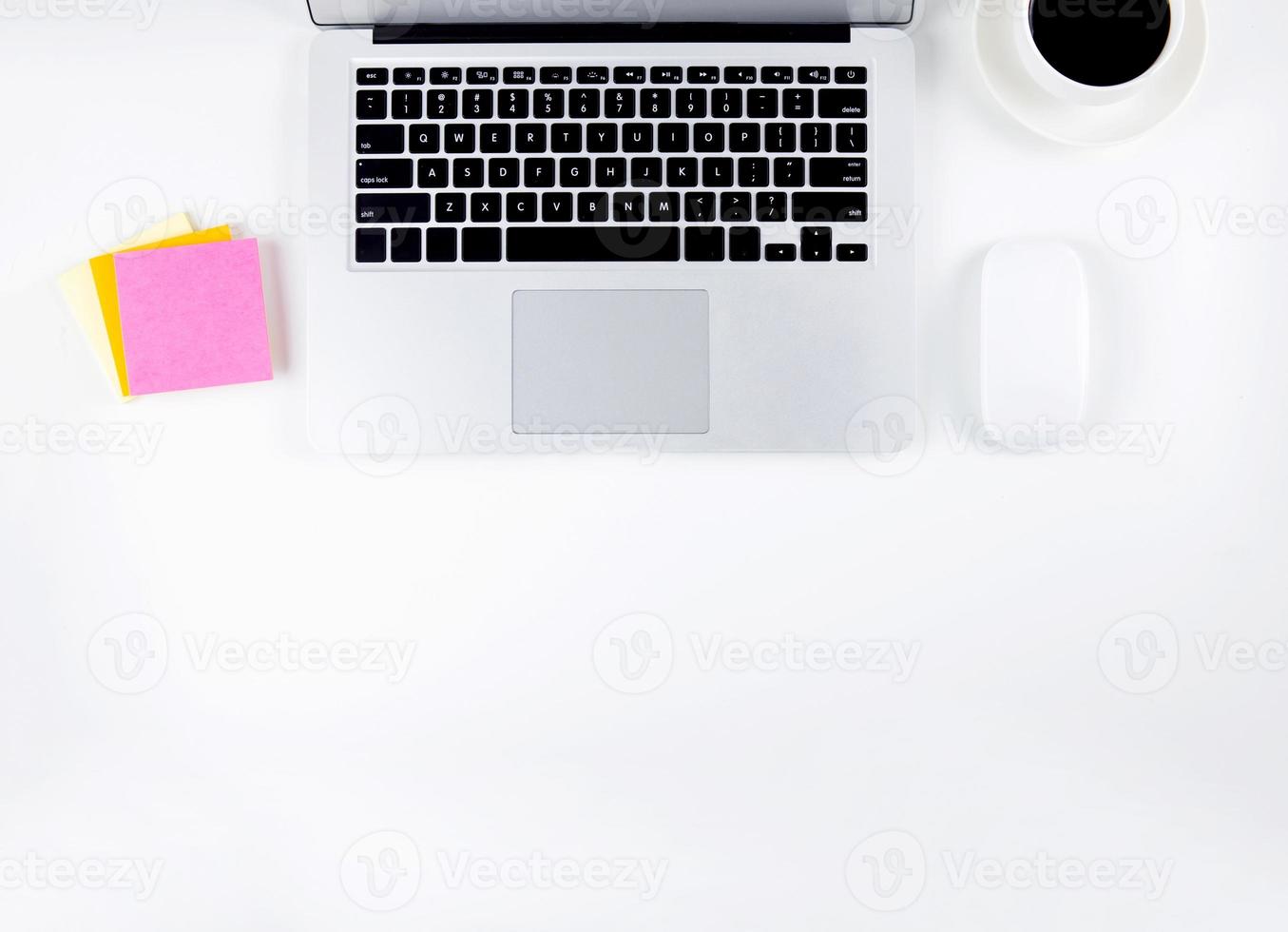 Top view of laptop computer and mouse, diary and notepad for reminder and a cup of coffee isolated on white background, notebook and supplies on desk office, business and workplace concept. photo