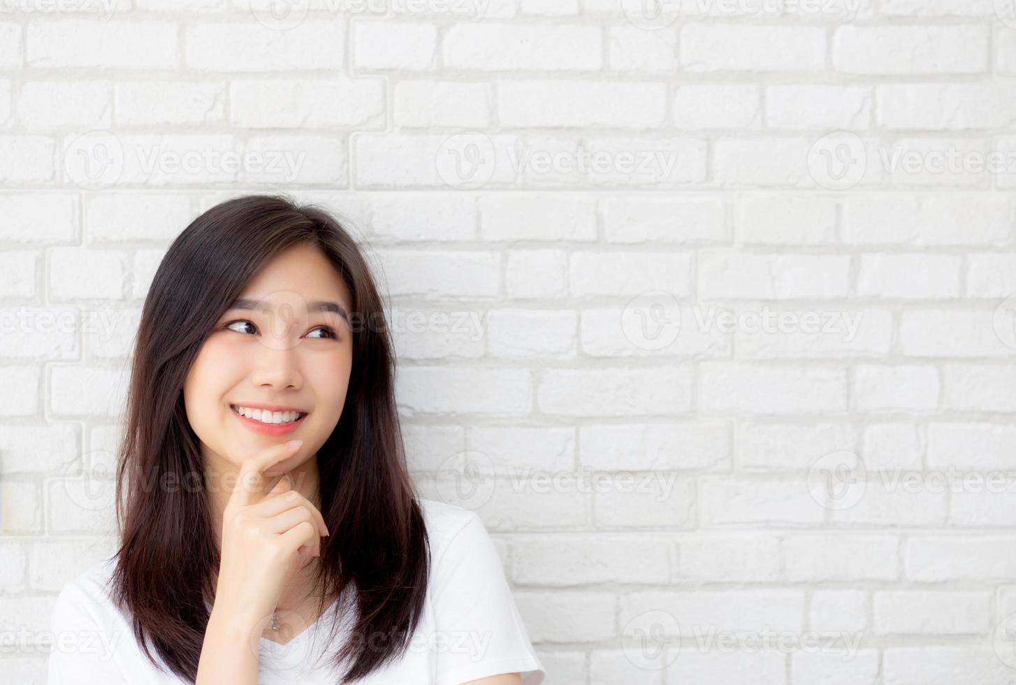 Beautiful portrait young asian woman confident thinking with cement and concrete background, girl standing expression serious or doubts with idea, lifestyle concept. photo