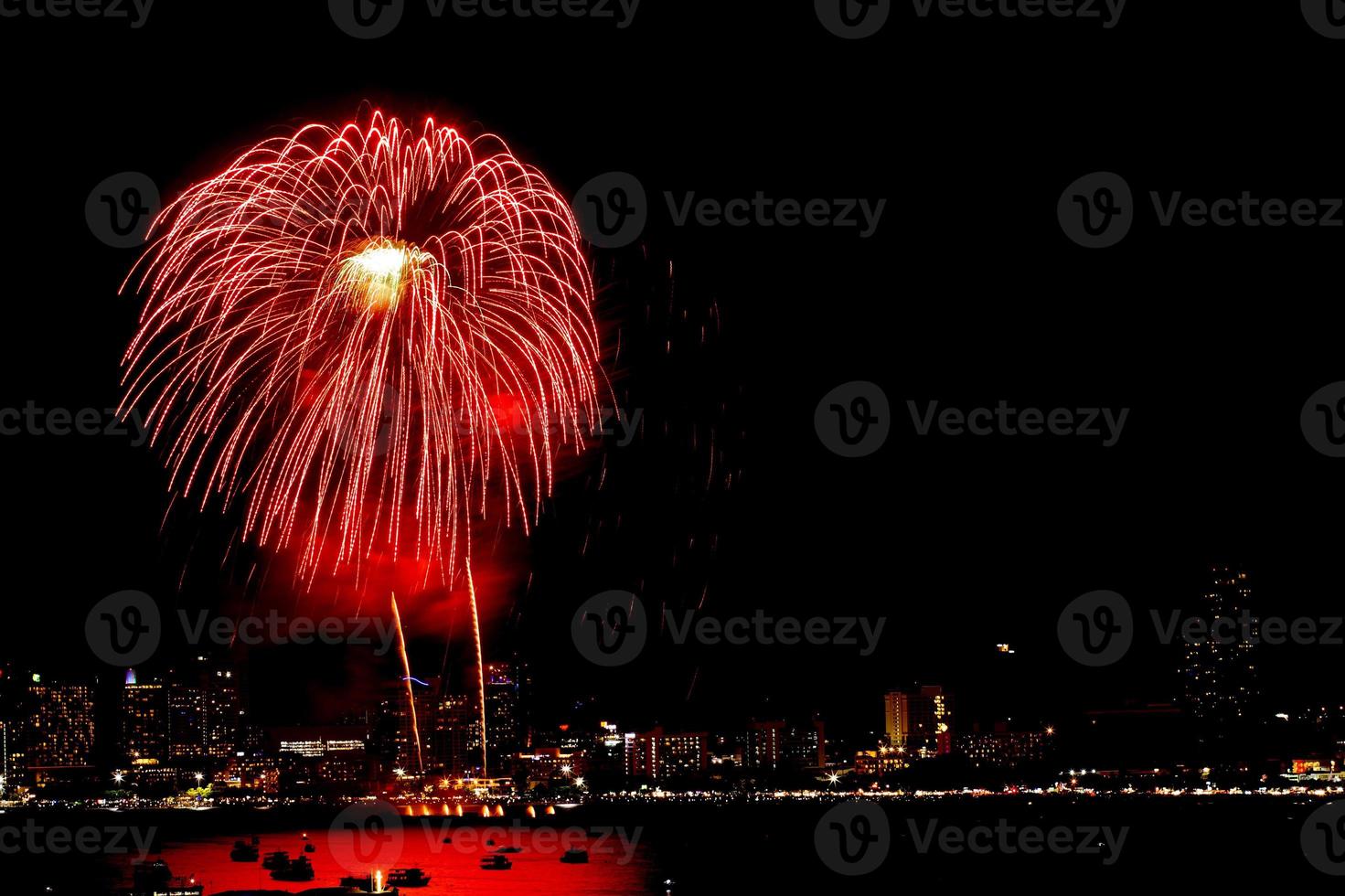 Many flashing fireworks with night cityscape background celebrate New Year. photo