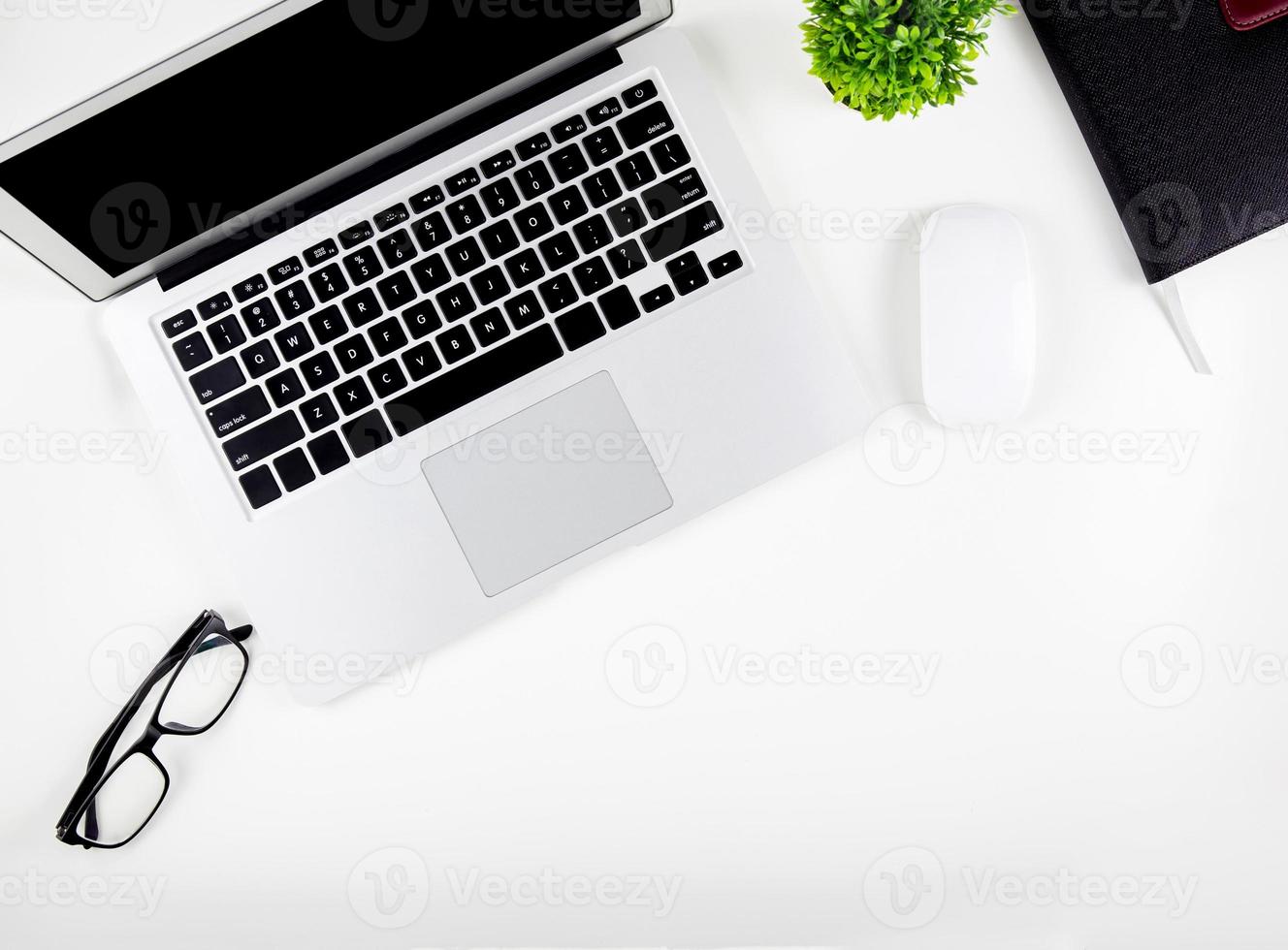 Top view of laptop computer with open display screen monitor, mouse and notepad and glasses isolated on white background, notebook or netbook with keyboard, communication technology concept. photo