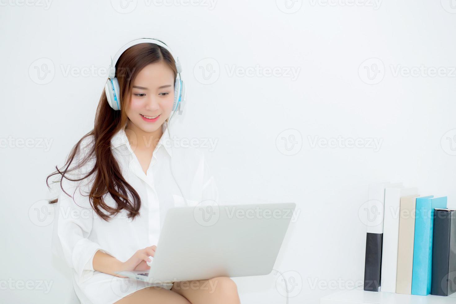 Beautiful young woman happy enjoy and fun listen music with headphone and laptop computer sitting in living room, lifestyle of girl relax sound radio with earphone, leisure and technology concept. photo