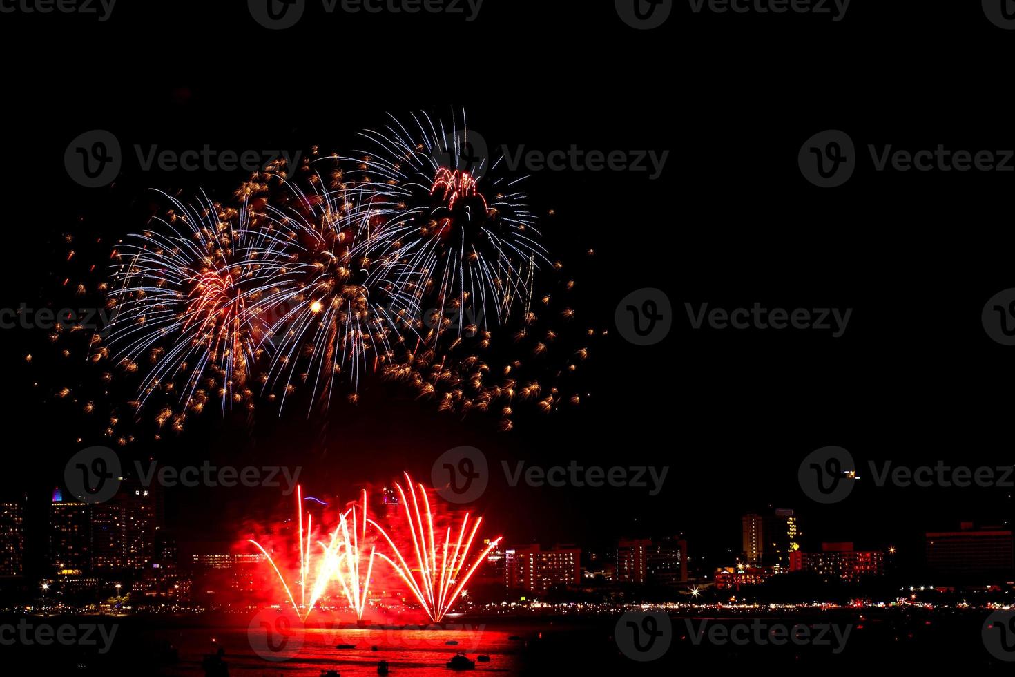 Many flashing fireworks with night cityscape background celebrate New Year. photo