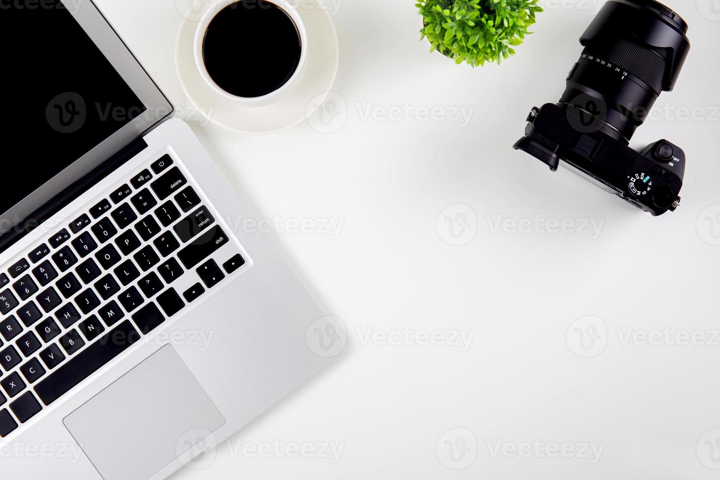 Top view of laptop with open display screen monitor and coffee and camera isolated on white background, notebook or netbook with keyboard work on desk office, communication technology concept. photo