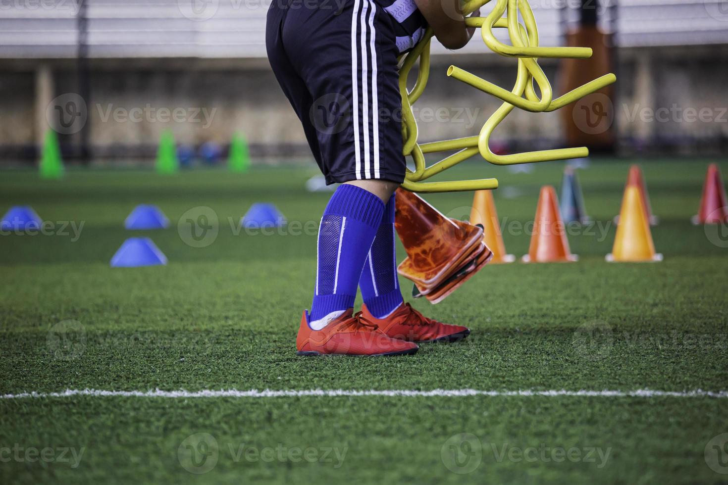 la pelota para niños está recogiendo tácticas en el campo de hierba con barrera para la habilidad de entrenamiento foto