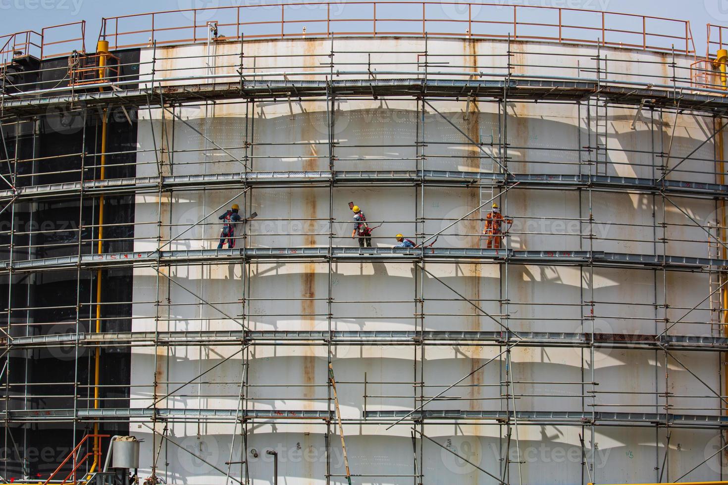Trabajadores de la construcción depósito de aceite instalación de andamios foto